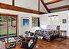 The primary sleeping area features a queen bed within the open-concept living space, with a privacy partition for added separation