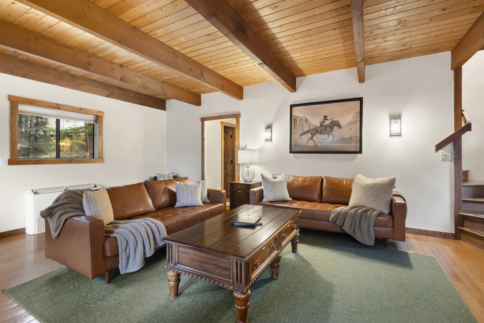 Expansive living room with plenty of seating, bay windows, traditional rock hearth, electric stove and smart TV.