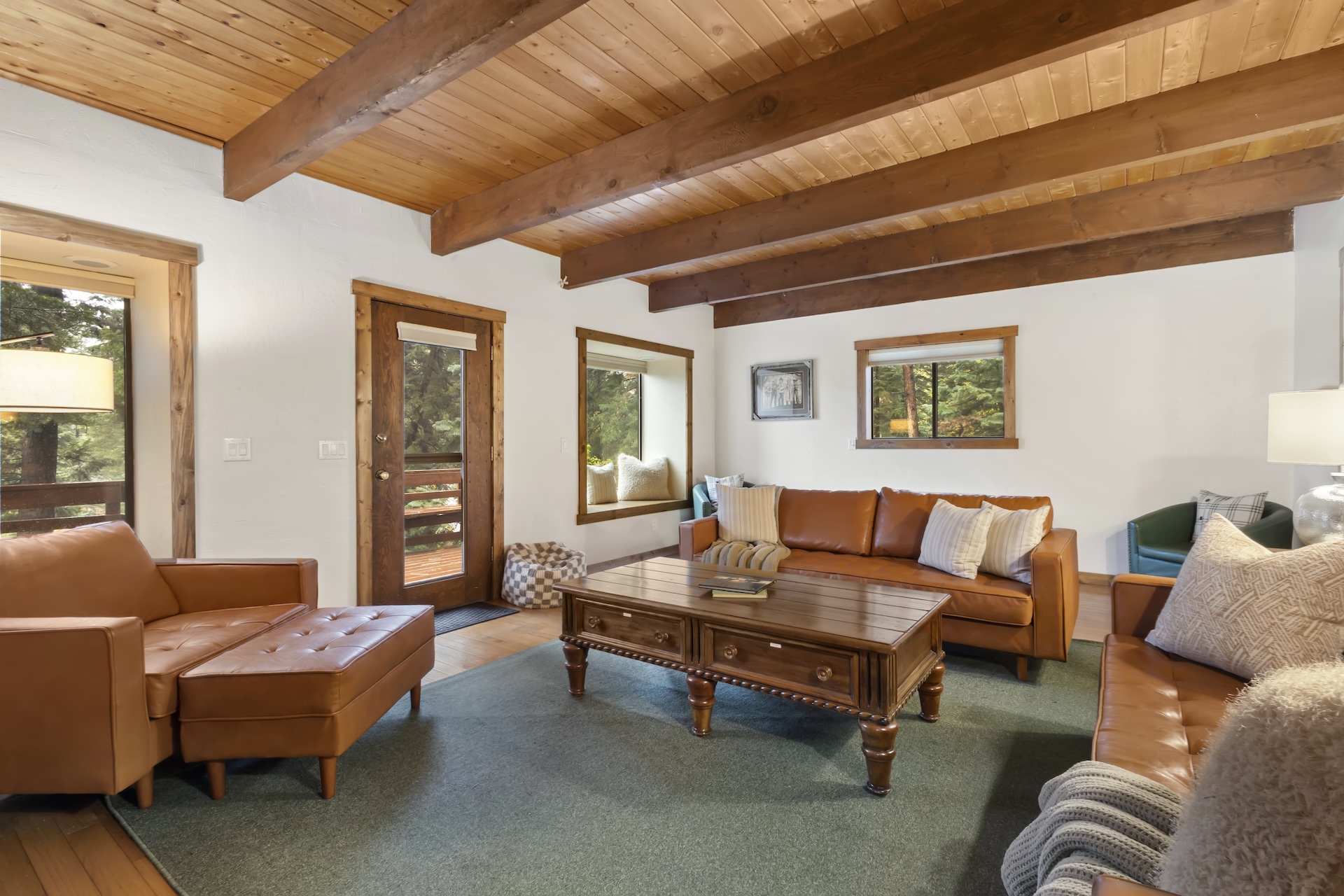 Expansive living room with plenty of seating, bay windows, traditional rock hearth, electric stove and smart TV.