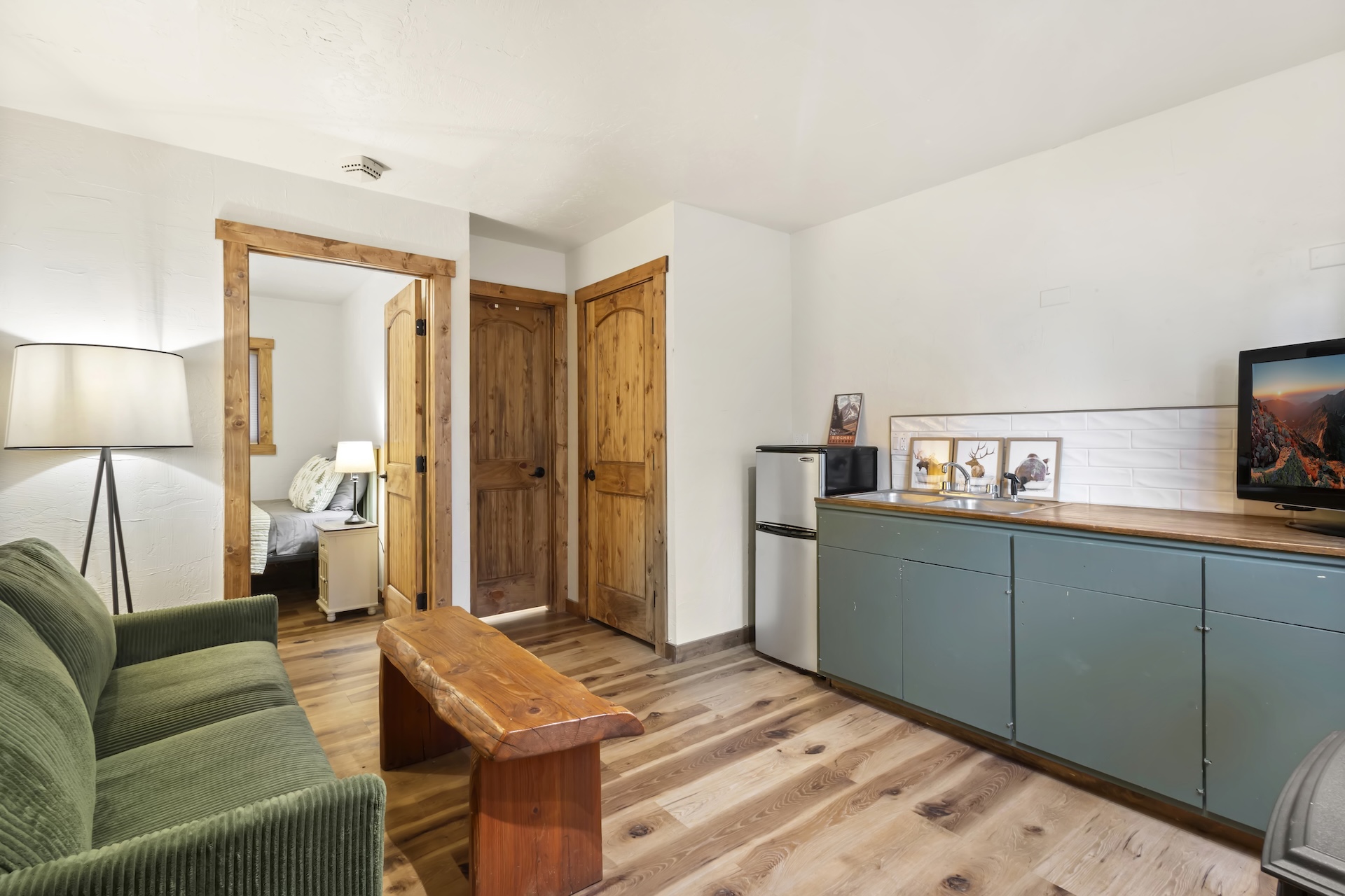 Ground-Floor Suite: Queen Bed with ensuite bathroom, private exterior entrance, and living area with TV, small refrigerator, wet bar and electric fireplace (1st Floor)