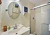 The king bedroom’s private ensuite bath features a bright vanity and a modern glass-door shower—perfect for a quiet reset after the beach, or a fast rinse before dinner in the Village.

