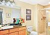 The guest bath includes a walk-in shower with tile surround, granite countertop, and a little splash of local character. Accessible from both the hallway and second bedroom.