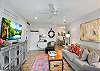 Bright and breezy living space with coastal décor, smart TV, and open flow into the dining area. The perfect spot to unwind after a day at the beach.

