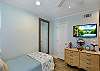 This second view of the guest bedroom shows off its added perk — a mounted flat-screen TV perfect for movie wind-downs or morning cartoons. Ocean Walk J-11 balances cozy and convenient at every turn.

