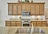 A centered view from the kitchen island—granite counters, stainless appliances, and ample storage round out the space designed for real living.

