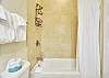The guest bath includes a full tub and shower combo with a curved curtain rod and built-in storage—easy, clean, and perfect for family use.

