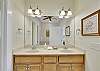 The primary en-suite bathroom includes a double vanity, private water closet, and a jetted soaking tub around the corner—everything you need to unwind after beach days.

