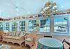 The Stumble Home’s airy sunroom brings the outdoors in, with walls of windows, cozy wicker seating, and vintage coastal touches.