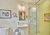Attached to the golden accent bedroom, this private en-suite bathroom brings clean lines and coastal color together. With a floating vanity, oversized mirror, and bold aqua walls, it’s a perfect example of how Sundowner blends comfort with character.