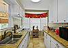 Seagull Cottage’s kitchen features full-size appliances, a Keurig coffee maker, and a charming bay window that floods the space with natural light—perfect for quick breakfasts or full family meals on St. Simons Island.

