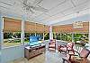 Bright and breezy sunroom with Smart TV and bamboo shades—perfect for morning coffee, quiet reading, or a cool indoor break with a view.

