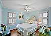 Second bedroom with a queen bed, ceiling fan, and soft filtered light—perfect for couples, teens, or anyone wanting their own space.

