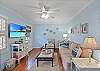 The living room at Seagull Cottage blends relaxed island style with comfort and tech—featuring a Smart TV, ceiling fan, and plenty of seating for movie nights or midday naps on St. Simons Island.

