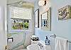 Additional half bath with vintage wallpaper and window light—ideal for early risers or busy mornings.