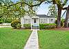 Seagull Cottage front exterior—located at 214 Ashantilly Street in St. Simons Island. Just a short walk to Pier Village, this adorable 2BR rental welcomes guests with mossy oaks, a fenced yard, and quiet island charm.