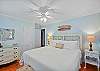 Peaceful primary bedroom with a king bed, ceiling fan, and coastal décor—rest easy after a day on St. Simons Island.

