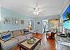 Additional view of the living room with bright windows and laid-back island style—ideal for reading, relaxing, or family movie nights.
