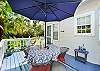 Perfect for coffee, cocktails, or card games under the palms—this umbrella-covered deck offers both comfort and island charm.

