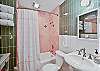 Main bathroom with a full tub/shower combo, colorful tile, and fresh towels provided—bright, clean, and guest-ready.