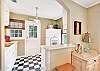 The updated kitchen at 204 Ashantilly Avenue offers backyard access, a double sink, and vintage charm—perfect for quick meals between beach runs.

