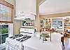 The kitchen at 204 Ashantilly Avenue offers a gas range, plenty of counter space, and a clear view into the dining and living areas—ideal for vacation cooking and connection.
