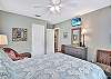 The primary bedroom at 204 Ashantilly Avenue includes a queen bed, wall-mounted TV, and plenty of space to recharge between island adventures.