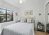 This sunny queen bedroom overlooks the treetops and rooftops of Harbour Oaks. It’s simple, quiet, and lets the breeze do most of the decorating.
