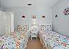 This twin bedroom brings the beach inside with ocean-themed quilts and fun wall art. Perfect for kids, teens, or adults who don’t mind a little fish watching them sleep.