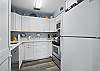This angle shows the full layout of the kitchen, from stove to sink. Clean white cabinetry, full-size appliances, and thoughtful extras make it easy to settle in—whether you're making dinner or just opening takeout.