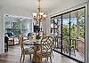 Slide open the glass doors and let the outdoors join you for breakfast. This shot connects the dining table, porch, and sitting nook into one open, sunlit space that feels like a vacation even if you're just eating leftovers.