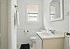This shared bathroom includes a walk-in shower, natural window light, and plenty of room to get ready without stepping on each other’s flip-flops. It’s easily accessed from both the front queen bedroom and the twin room.

