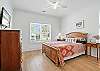 A second queen bedroom with hardwood floors, natural light, and a smart TV—ideal for guests who like their vacation rentals calm, clean, and clutter-free.