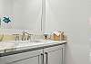 The home includes a half bath just off the living room—ideal for quick cleanups, beach days, and keeping everyone out of the ensuite.