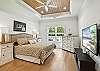 The primary bedroom in this St. Simons Island vacation home features a king bed, tray ceiling, smart TV, and private bath—your own peaceful retreat after Redfern cocktails.