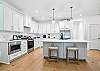 This St. Simons Island vacation rental features a fully equipped kitchen with a large center island, full-size appliances, and bar seating for casual mornings or late-night snacks.