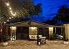 Buck a Roo - upscale luxury lounge w/ rattan sofa & matching chair with white cushions. Faux gas & Party lights.