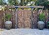Cedar high fence, massive antique beams, 200 year old doors & large rustic pots add character.