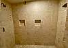 Cream tile shower with double heads for a luxurious couples shower.