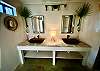 Cool blown glass wall vases filled with palm leaves, vessel sinks and thick stone counters.