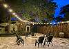 Custom white rock fire pit under party lights overlooking the romantic tropical garden.
