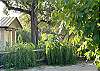Covered front porch overlooks lush greenery, fields, mountains and mature trees.