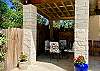 Left side of the Cabana is a custom made rod iron table and chairs with white cushions, perfect for al fresco dining.