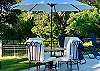 White poolside dining table and umbrella.