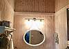 Historic Cabin bathroom is super cute with vaulted ceiling, whitewashed beadboard walls, tile floor and lots of hooks for all your towels and swimsuits.