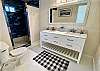 Step into the luxury ensuite bathroom with marble counters, stunning floor to ceiling tile shower with bench seating & glamorous crystal lighting.