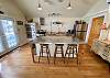 Professional Kitchen #2. Wood floors, vaulted ceiling, 3 ovens, 4 sinks, porch, views of pool.