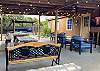 Texas size outdoor entertainment area with plenty of dining tables, seating and smart tv.