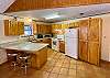 Kitchen has new 2022 granite counters, tile floors, bar with stools.