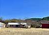 THE HOME SITS BACK UNDER THE MOUNTAIN RANGE AND ABOVE THE FRIO RIVER.