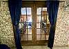 THE FRENCH DOORS LOOKING FROM INSIDE THE FAMILY ROOM HAS COOL BRICK WALLS AND TILE FLOORS.